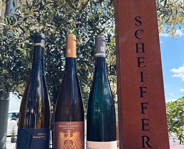 Weinflaschen vor Wegweiser „Zum Scheiffer“ bei der Natur-Genuss-Tour in Dernau im Ahrtal.