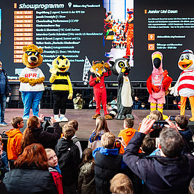 Verschiedene Tier-Maskottchen stehen auf einer Bühne